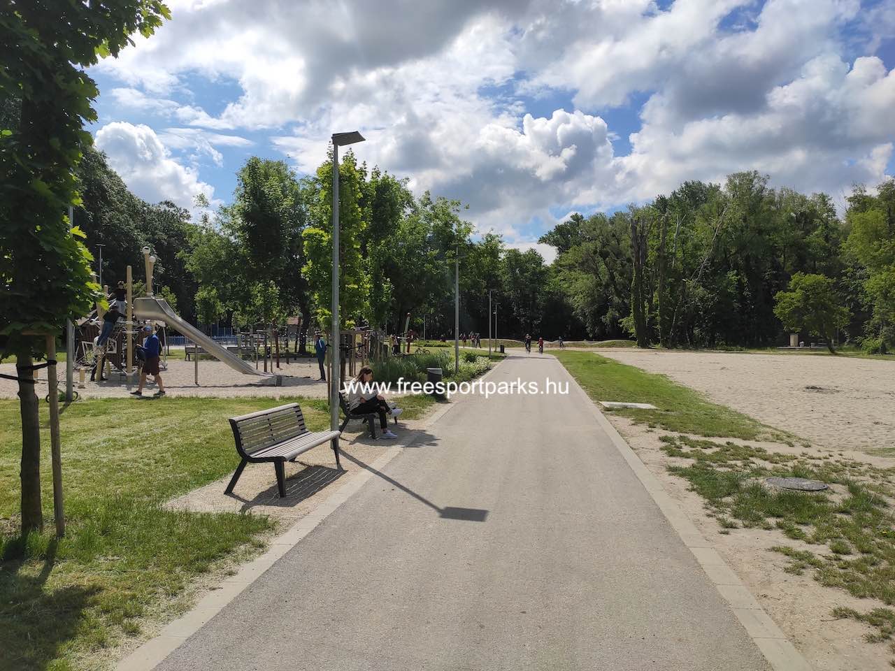a parkon hosszában végig vezető sétány padokkal és megvilágítással - Építők Parkja Tata - Free Sport Parks térkép